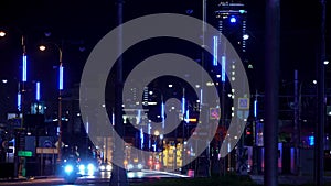 Street of a night city with moving cars along street lamps with a skyscraper on the background, Ekaterinburg, Russia