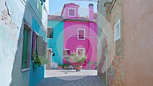 Street between old colorful houses in Burano on sunny day