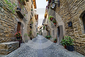 Street of an old medieval town with stone houses and cobbled floors, street lamps and an atmosphere of bygone times