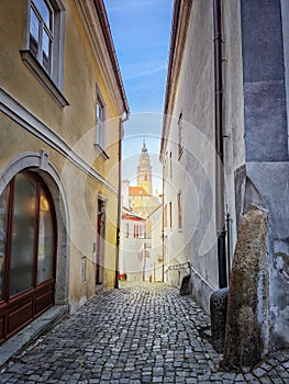 Street in the old town of Cesky Krumlov and view through the castle tower. It is in southern Bohemia and the city belongs to the