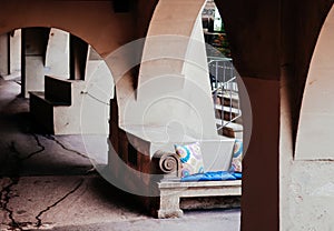 Street outdoor seat with colourful cushion under arch arcade in