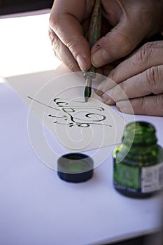 Street painter writing a celtic name with green pen