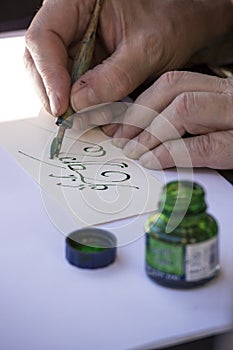 Street painter writing a celtic name with green pen