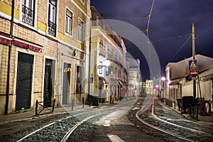 street pavement with tram railways at a stormy night empty of people in Lisbon, Portugal