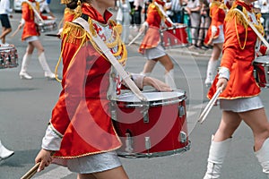 Street performance. Close-up of female drummers hands in red vintage uniform at the parade