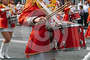 Street performance. Close-up of female drummers hands in red vintage uniform at the parade