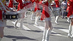 Street performance on the occasion of the holiday. Young girls drummer in red at the parade