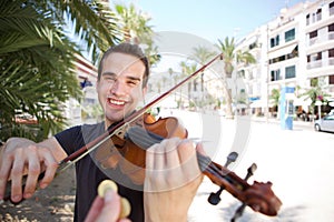 Street performer playing violin being paid money