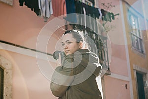 A street photographer or a young woman takes pictures of authentic houses in Lisbon in Portugal. A professional