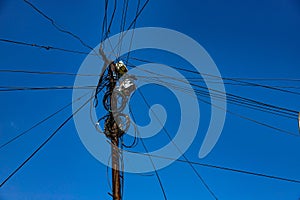 Street pole with many electrical wires and fiber optic cables, Fiber-optic cable against the blue sky