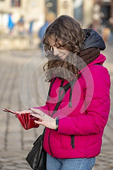 Street portrait of a cheerful woman 30-35 years old with curly hair and delicate features against the backdrop of the urban landsc