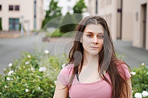 Street portrait of a serious young woman outdoor. Beautiful young female in urban setting with copy space