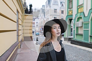 Street portrait of a stylish woman on the background of the street of an old beautiful town.