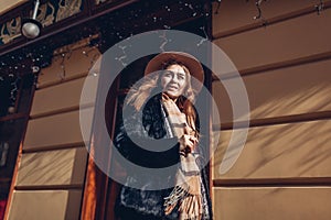 Street portrait of woman. Female modern fashion. Stylish girl wearing fur coat hat and scarf. Autumn accessories