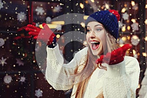 Street portrait of young beautiful woman acting thrilled, wearing stylish knitted clothes. Model expressing joy