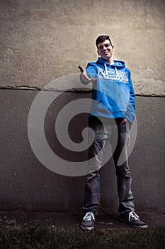 Street portrait of young boy in blue sweatshirt with modern eyeglasses