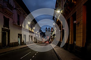 Street of Quito and Basilica del Voto Nacional at night - Quito, Ecuador