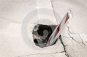 Street reconstruction or construction barricade traffic danger caution sign cover the open hole of damaged and cracked asphalt on