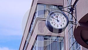 Street round clock on the background of high urban buildings