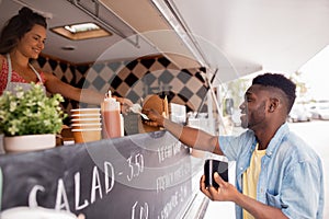 African american man buying wok at food truck