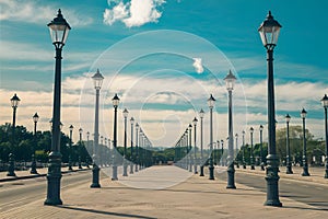 Street scene features orderly rows of lampposts under sunny skies