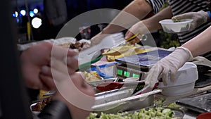 Street Seller in Rubber Gloves Weighs Salad in a Lunch Box on Electronic Scale