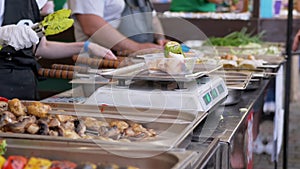 Street Seller Weighs a Fried Piece of Kebab, zucchini on an Electronic Scale