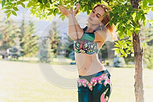 Street shaabi dance and urban dancer concept - Cheerful belly dancer dancing with arabic music on the street.