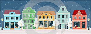 Street with shops and houses at winter night. Sweet shop, candy store, confectionery, bakery with Christmas decoration.