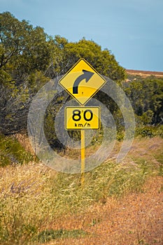 Street sign in Australia warning right curve ahead speed 80 in dry land