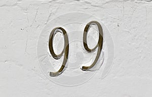 Street sign number 99 on a white wall