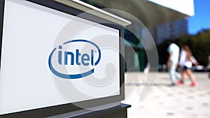 Street signage board with Intel Corporation logo. Blurred office center and walking people background. Editorial 3D