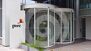 Street signage board with PricewaterhouseCoopers PwC logo. Modern office building. Editorial 3D rendering