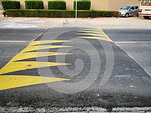 Street speed bump in the road for safety painted with yellow color