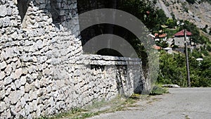 Street With A Stone Wall And An Old House with terace
