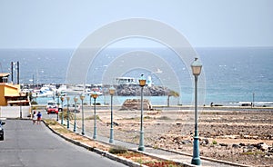 A street with street lamps leading to the ocean and the marina in Castillo Caleta de Fuste, Fuerteventura.