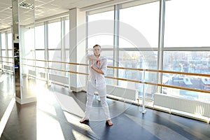 Street style dancer making hand movements near big window.