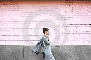 Street Style Shoot Woman on Pink Wall. Swag Girl Wearing Jeans Jacket, grey Dress, Sunglass. Fashion Lifestyle Outdoor