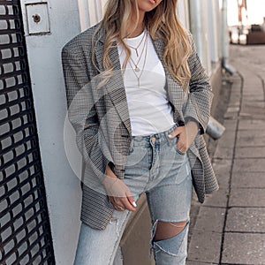 Street style of stylish fashion outfit in details outdoors. Close-up photo, of young fashion blogger wearing in plaid blazer