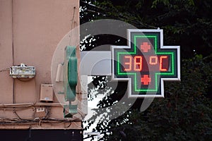 Street thermometer of a pharmacy at 38 degrees celsius photo