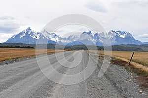 Street to Torres del Paine National Park in Chile, Patagonia with snow covered mountains in background