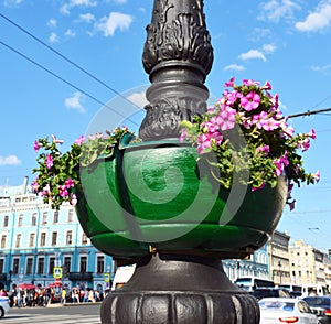 Street vase with red flowers on a column