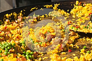 Street vender, cooking paella, in large pan at a tropical farmers market photo