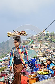 A street vendor carrying tray of freshly cooked yam, cassava and alike on her head