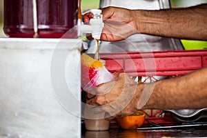 Street vendor in the city of Cali in Colombia preparing and selling a traditional sweet water ice called cholado