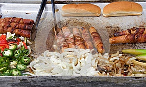 Street vendor grill with hot dogs and onions