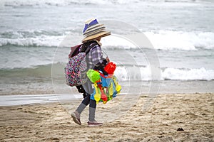Street vendor in Rosarito Mexico carrying hats and toys on a beach photo