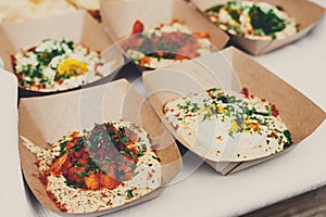 Street vendor`s hummus, closeup of snacks in craft package