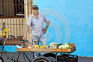 Street vendor selling fruit and vegetables on his bike in the streets of Camaguey, Cuba