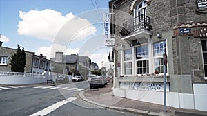 Street view of a beautiful european city with many cars parked along the road. Action. Beautiful hotel, brick building